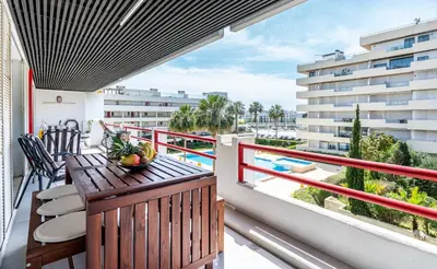 a balcony with a table and chairs and a view of a building at Marina Luxor in Vilamoura