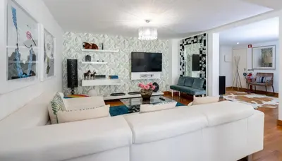 a living room with a white couch and a tv at Marina Luxor in Vilamoura