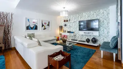 a living room with a white couch and a tv at Marina Luxor in Vilamoura