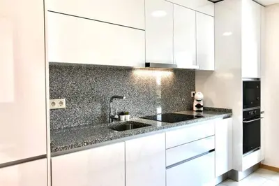 a kitchen with white cabinets and a sink at Falesia beach l roof top pool in Albufeira