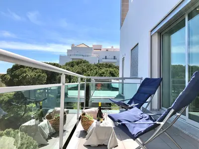 two chairs on a balcony with a view of a city at Falesia beach l roof top pool in Albufeira