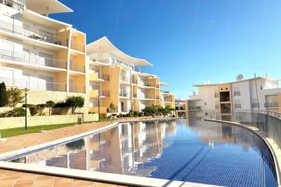 a swimming pool in front of a apartment building at Albufeira l encosta da Orada wonderful sea view in Albufeira