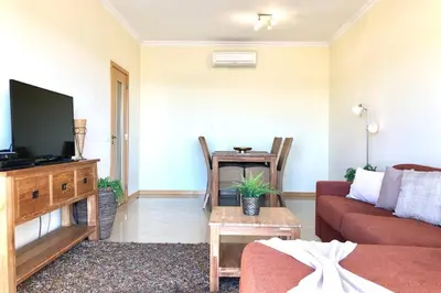 a living room with a couch and a tv at Albufeira l encosta da Orada wonderful sea view in Albufeira