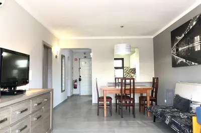 a living room with a table and a dining room at Poente da Aldeia apartment in Albufeira