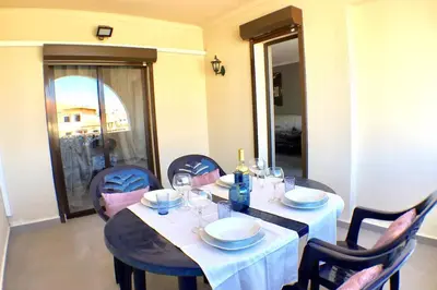 a dining room table with a white table cloth and chairs at Poente da Aldeia apartment in Albufeira
