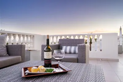 a bottle of wine and a plate of food on a table at WHome | Prime Hideaway Luxury Villa in Quarteira