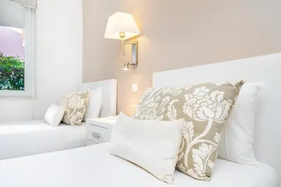 a white bedroom with a bed and a window at WHome | Prime Hideaway Luxury Villa in Quarteira
