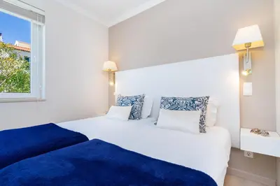 two beds in a white room with a window at WHome | Prime Hideaway Luxury Villa in Quarteira