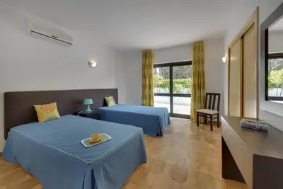 a hotel room with two beds and a television at VILLA COELHO in Albufeira