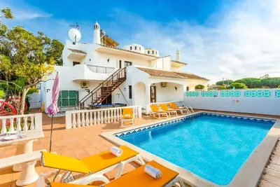 a villa with a swimming pool and a house at VILLA COELHO in Albufeira