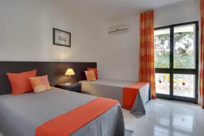 a hotel room with two beds and a window at VILLA COELHO in Albufeira
