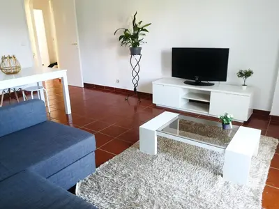 a living room with a blue couch and a tv at Pool and Garden Village-near beach in Albufeira