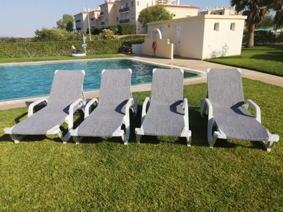 a lawn with palm trees in front of a building at Pool and Garden Village-near beach in Albufeira