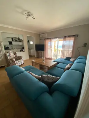 a living room with a blue couch with people laying on it at Casa da azinheira in Loulé