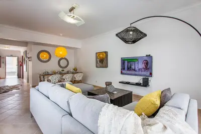 a living room with a couch and a tv at Villas Mar e Brisa in Albufeira