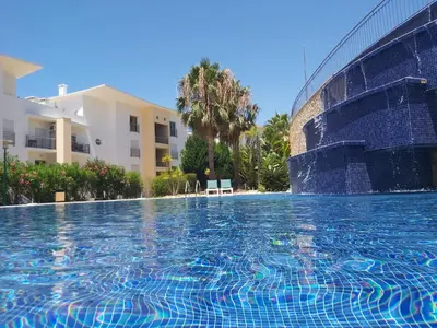 a swimming pool in front of a building at Sunny Apartment with sea view in Albufeira in Albufeira