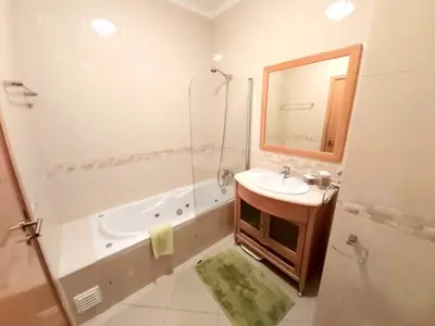 a bathroom with a tub and a sink and a shower at Sunny Apartment with sea view in Albufeira in Albufeira
