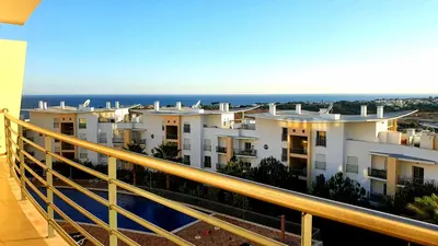 an apartment balcony with a view of the ocean at Sunny Apartment with sea view in Albufeira in Albufeira
