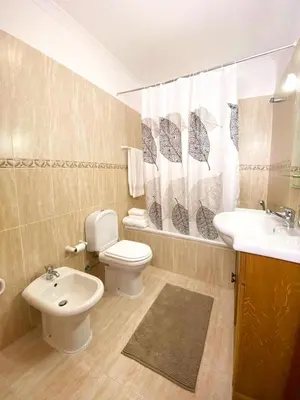 a bathroom with a toilet and a sink and a toilet istg at Apartamento Carvalhal in Quarteira