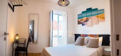 a bedroom with a white bed and a window at Alagoa Terrace Guesthouse in Faro