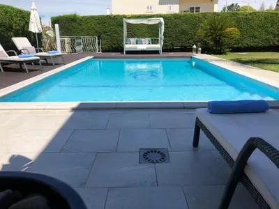 a large swimming pool with a bench and a table at Casa Corais in Guia