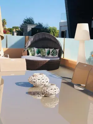 a patio with a bench and two rocks on a table at Casa Coralea in Guia