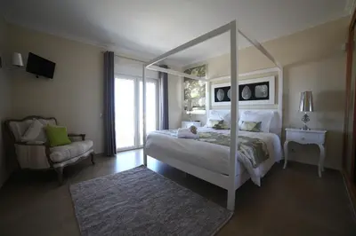 a bedroom with a canopy bed and a chair at Casa Coralea in Guia