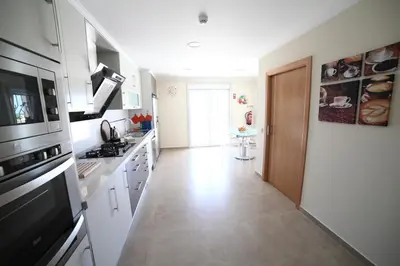 a kitchen with white appliances and a hallway at Casa Coralea in Guia
