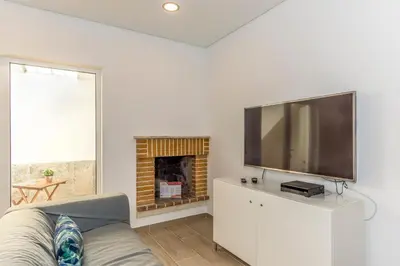 a living room with a flat screen tv and a fireplace at FLH Faro Central House with Terrace in Faro