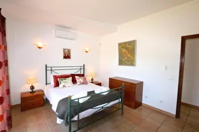 a bedroom with a bed with white sheets and red pillows at Vila Girasol, 171 - Clever Details in Vilamoura