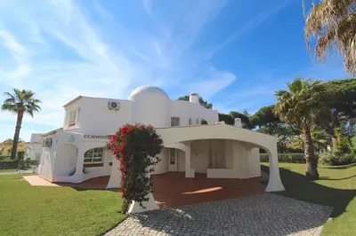 a white house with palm trees in front of it at Vila Girasol, 171 - Clever Details in Vilamoura