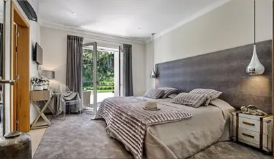 a bedroom with a large bed and a large window at Villa Gondra - Quinta do Lago - heated pool in Almancil