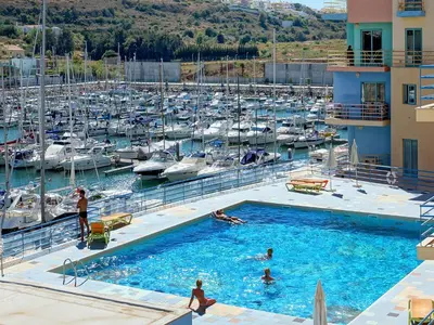 a group of people in a swimming pool near a marina at Marina Sand Residence in Albufeira