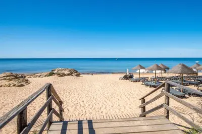 a beach with chairs and umbrellas and the ocean at Charm Apartment T2 All With Big Terrace Albufeira Self check-in in Albufeira