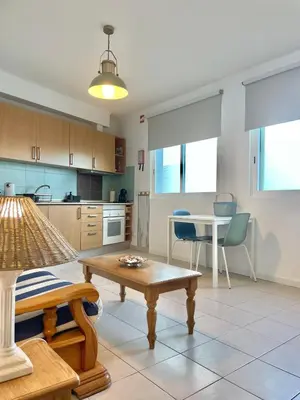 a living room with a table and a kitchen at Bayview Apartment 106 in Albufeira