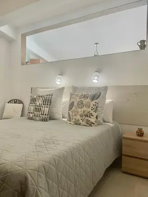 a white bedroom with a large bed with pillows at Bayview Apartment 106 in Albufeira