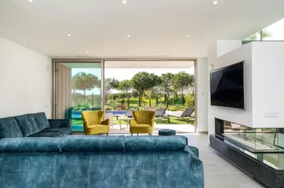 a living room with a blue couch and a tv at Victoria Lux by SAPvillas in Vilamoura