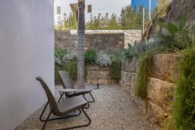 a patio with two chairs and a table and a wall at Victoria Lux by SAPvillas in Vilamoura
