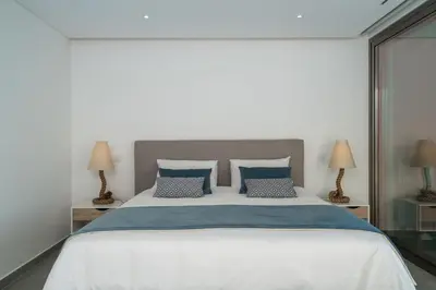 a bedroom with a large white bed with blue pillows at Victoria Lux by SAPvillas in Vilamoura
