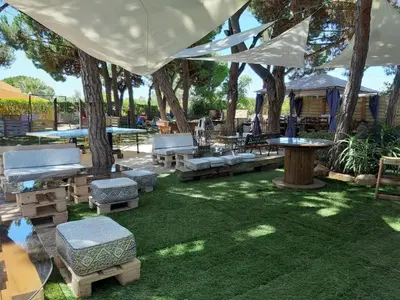 a patio with benches and tables and trees at Quinta Vita - Vila Maça in Loulé