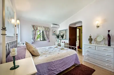 a bedroom with a bed and a dresser and a mirror at Amizade by Algarve Villa Holidays in Albufeira