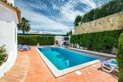 a swimming pool in a backyard with a brick wall at Amizade by Algarve Villa Holidays in Albufeira