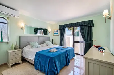 a bedroom with a bed with a blue blanket at Amizade by Algarve Villa Holidays in Albufeira