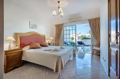 a bedroom with a bed and a view of the ocean at Apt O Monte C near the beach by Algarve Villa Holidays in Albufeira