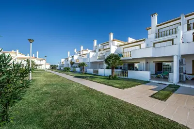a row of white apartment buildings with a green lawn at Apt O Monte C near the beach by Algarve Villa Holidays in Albufeira