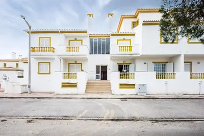 a white house with yellow accents on a street at Apt O Monte S by Algarve Villa Holidays in Galé
