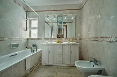 a bathroom with two sinks and a bath tub and a mirror at Apt Galé Mar 11 by Algarve Villa Holidays in Galé