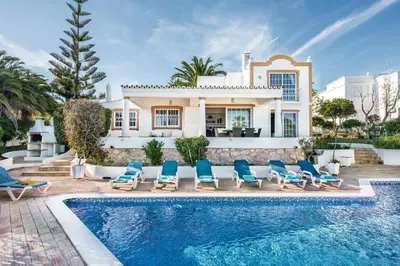 a villa with a swimming pool in front of a house at Buganvilia by Algarve Villa Holidays in Guia