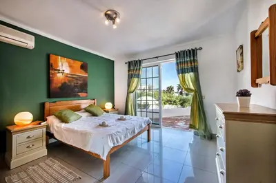 a bedroom with a bed with a green wall at Buganvilia by Algarve Villa Holidays in Guia