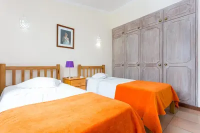 a bedroom with two beds and an orange blanket at Helmar by Algarve Villa Holidays in Galé